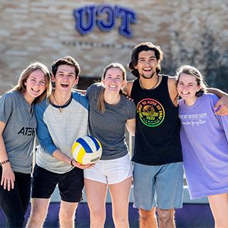 Five TCU students on the sand volleyball court